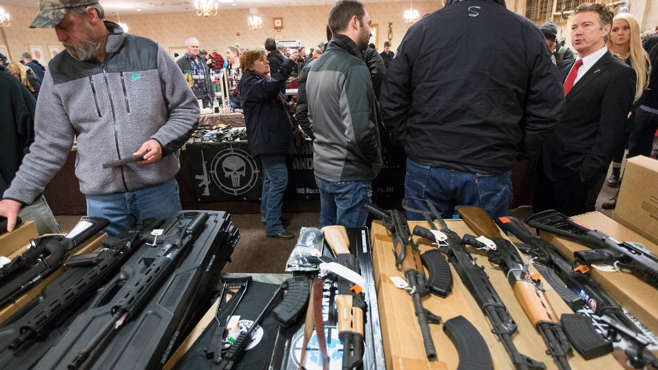 Sen. Rand Paul, R-Ky., right, meets with customers during a campaign stop at a gun show at Bektash Shrine Center, Saturday, Jan. 23, 2016, in Concord. (AP Photo/John Minchillo)