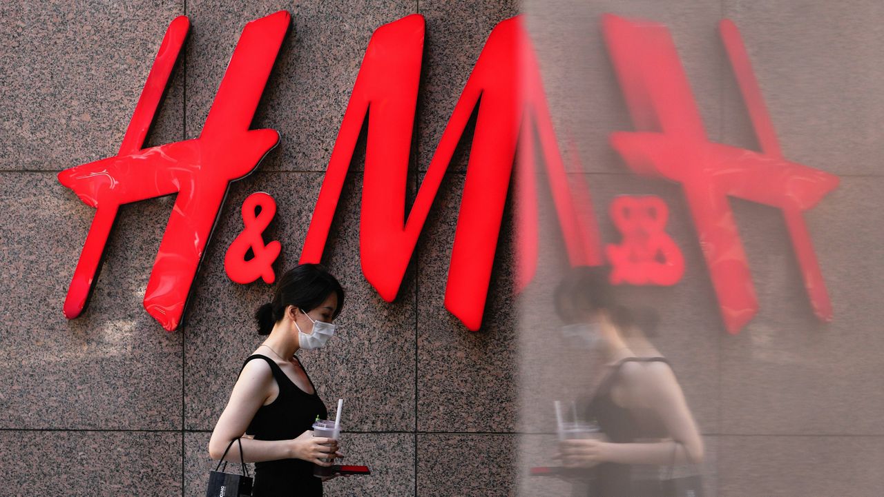 A woman walks by a Sweden-based clothing company H&M at a shopping mall in Beijing, Wednesday, June 21, 2023. (AP Photo/Andy Wong) 