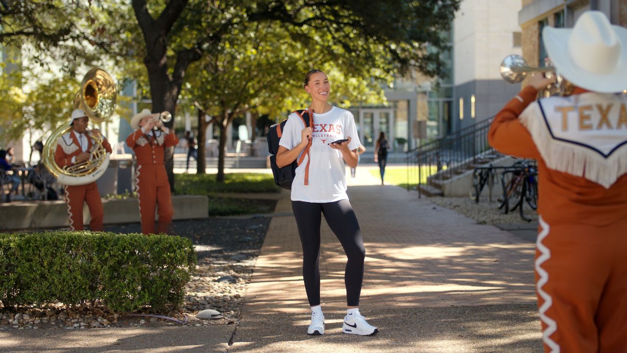 Madisen Skinner, a volleyball player at the University of Texas at Austin, appears with members of the Longhorn Band in a H-E-B commercial. (Courtesy H-E-B)