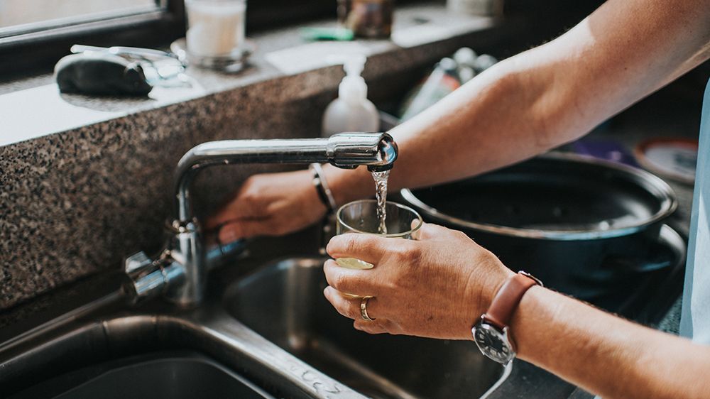 water being poured from a tap into a glass