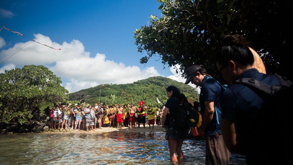 Crew members partake in ceremonial protocol upon arriving at Taputapuātea. (Photo courtesy Polynesian Voyaging Society/Jonathan “Sav” Salvador)