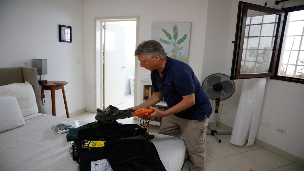 Richard Phillips, a 65-year-old man from the Canadian capital, Ottawa, packs his suitcase in Port-au-Prince, Haiti, Friday, March 8, 2024.