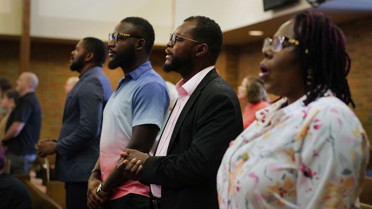 Members of the Haitian community in Springfield, Ohio, from left, Lindsay Aime, James Fleurijean, Viles Dorsainvil, and Rose-Thamar Joseph, stand for worship at Central Christian Church, on Sunday, Sept. 15, 2024. (AP Photo/Jessie Wardarski)