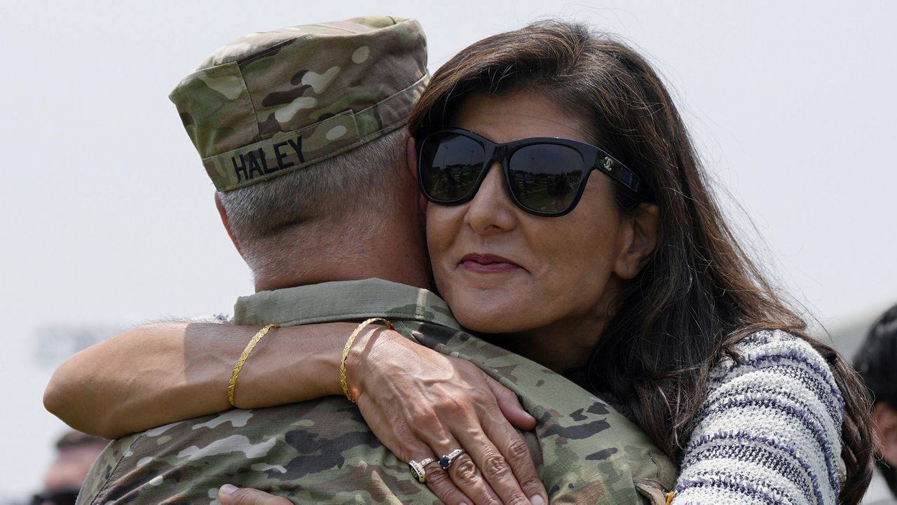 Republican presidential candidate Nikki Haley, right, hugs her husband, Maj. Michael Haley, following a deployment for his unit of the South Carolina National Guard unit on Saturday, June 17, 2023, in Charleston, S.C. Michael Haley's year-long deployment to Africa will encompass much of his wife's campaign for the 2024 GOP presidential nomination. (AP Photo/Meg Kinnard)