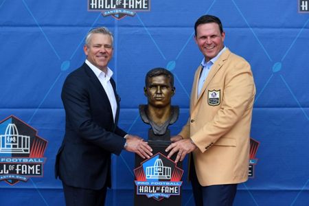 Former NFL player Bryant Young, right, poses with his bust and presenter  Edward DeBartolo Jr., during an induction ceremony at the Pro Football Hall  of Fame in Canton, Ohio, Saturday, Aug. 6