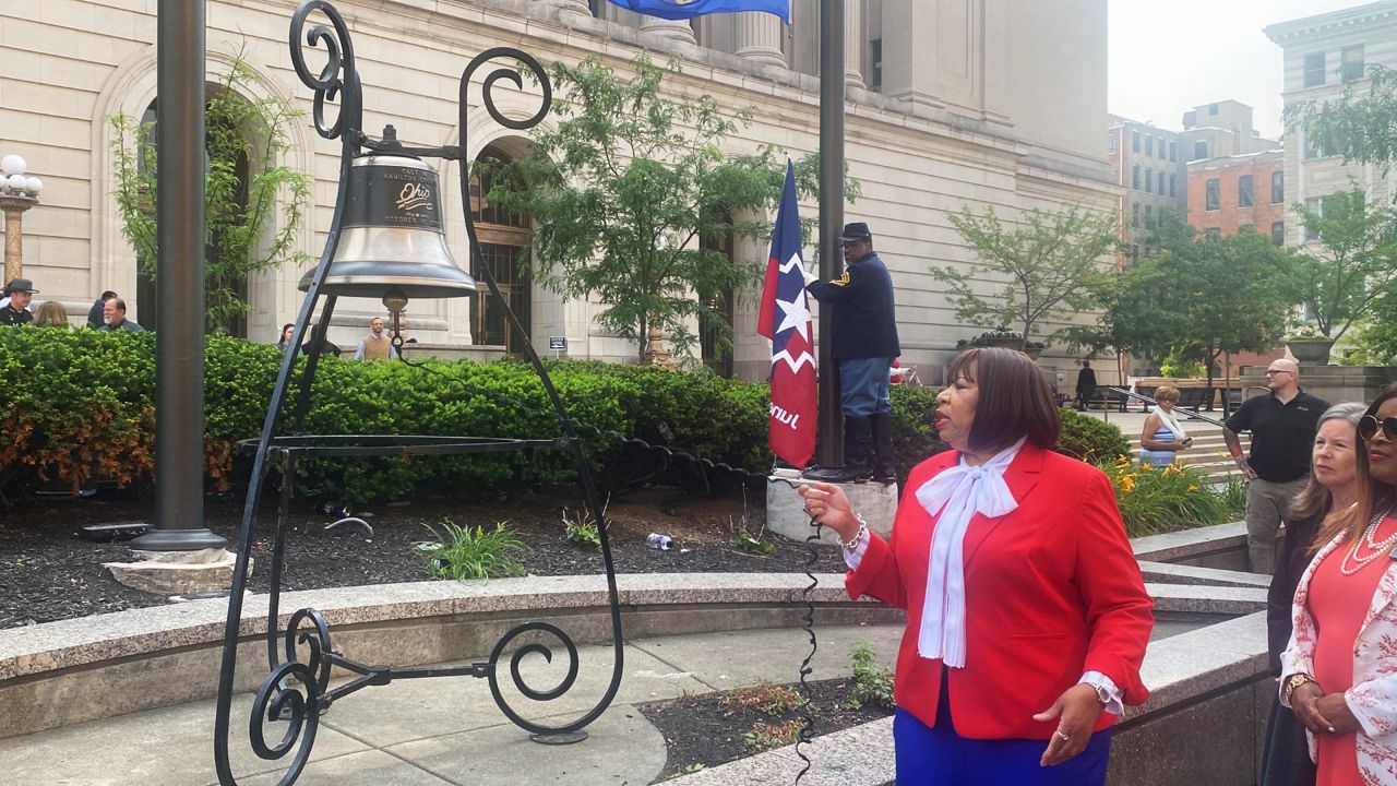 County officials and invited dignitaries took turns ringing a bell outside the Hamilton County Courthouse during the flag-raising ceremony. (Spectrum News 1/Casey Weldon)