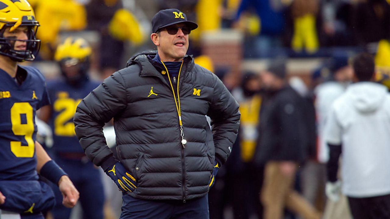 Michigan head coach Jim Harbaugh watches warmups before an NCAA college football game against Ohio State in Ann Arbor, Mich., Saturday, Nov. 27, 2021. Michigan won 42-27. (AP Photo/Tony Ding, File)