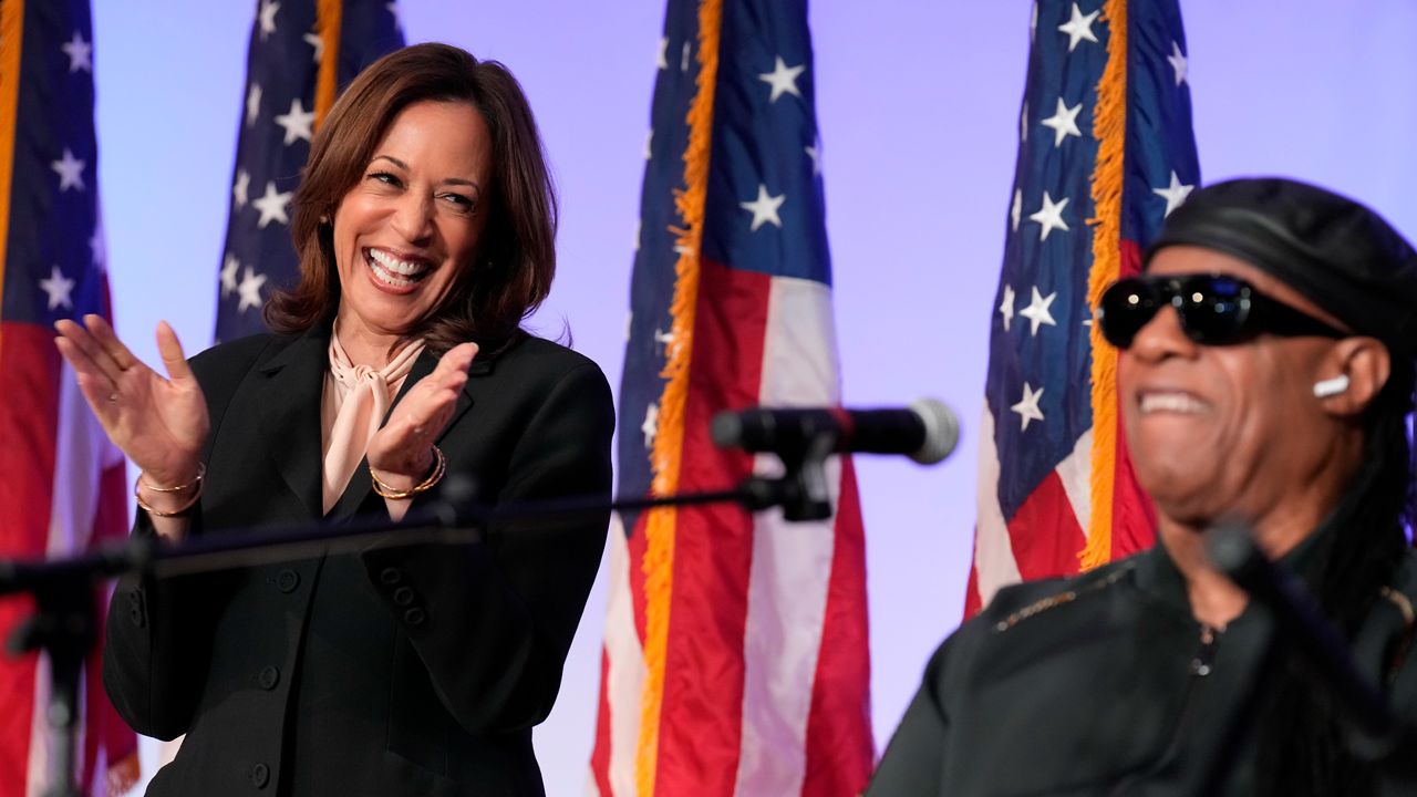 Democratic presidential nominee Vice President Kamala Harris listens as Stevie Wonder performs "Redemption Song" during a church service and early vote event at Divine Faith Ministries International, Sunday, Oct. 20, 2024, in Jonesboro, Ga. (AP Photo/Jacquelyn Martin)