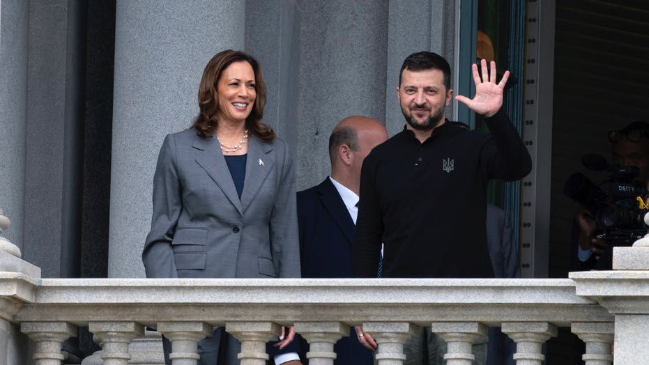 Ukraine's President Volodymyr Zelenskyy, accompanied by Vice President Kamala Harris, waves from the balcony of the Eisenhower Executive Office Building on the White House complex in Washington, Thursday, Sept. 26, 2024. (AP Photo/Jose Luis Magana)