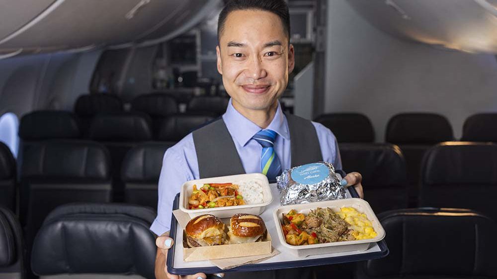 An Alaska Airlines flight attendant shows off the new hot meal options. (Photo courtesy of Alaska Airlines)