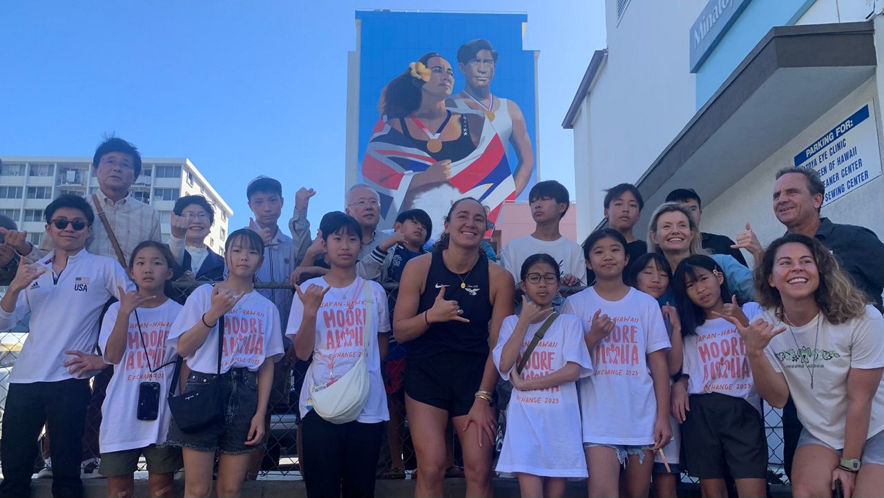 Hawaii-born surfing world champion Carissa Moore, middle, posed with students from Japan in front of a King Street building mural bearing her likeness and that of fellow Olympic gold medalist Duke Kahanamoku as part of an exchange program put on by her fundraiser, Moore Aloha, in Honolulu this week.