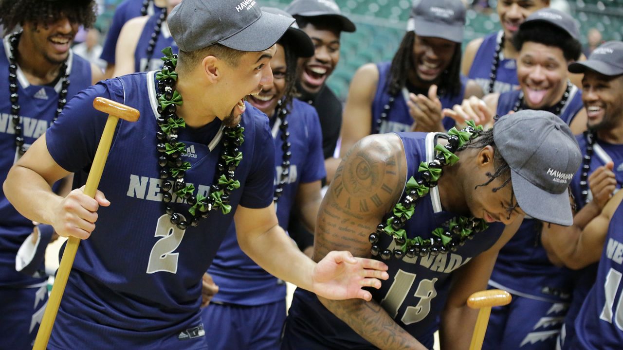 Nevada guard Jarod Lucas, left, the Hawaiian Airlines Diamond Head Classic Most Outstanding Player, made a paddling motion with fellow Wolf Pack all-tournament team member Kenan Blackshear with their koa trophies after beating Georgia Tech for the tournament title on Sunday night.