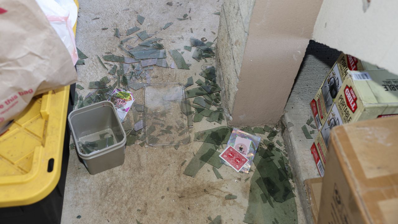 Broken glass from a blown out window is seen at the property of Evelyn Paguirigan after a New Year's Eve fireworks explosion at a home across the street. (AP Photo/Marco Garcia)