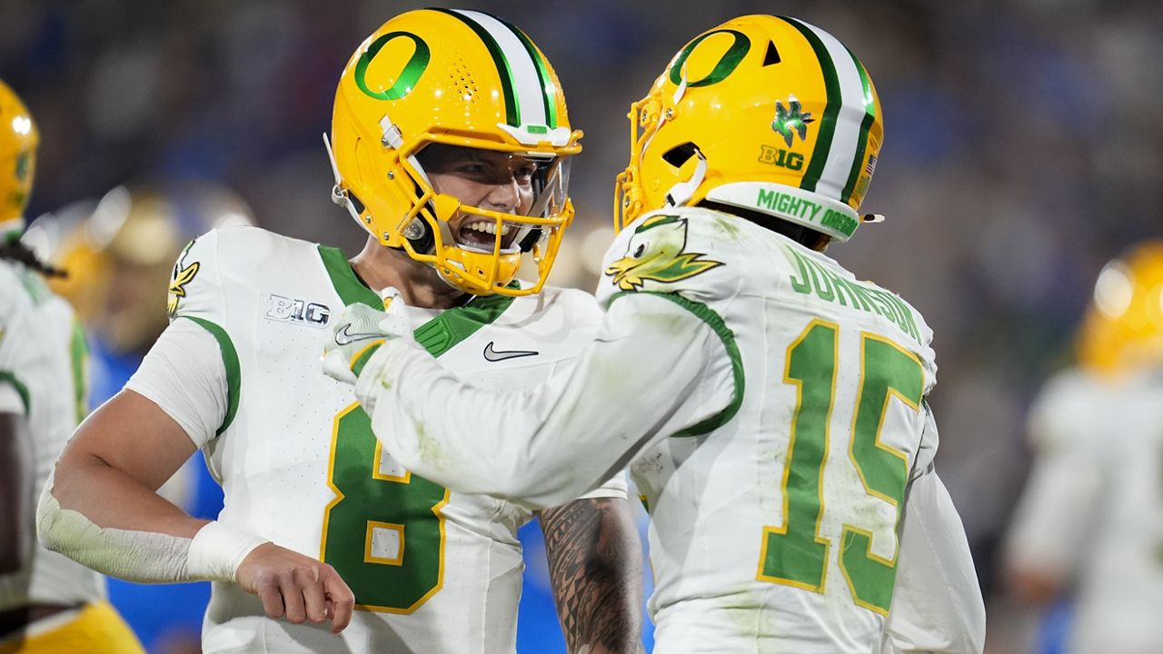 Oregon quarterback Dillon Gabriel, left, celebrated after throwing a touchdown pass to wide receiver Tez Johnson (15) in the first half against UCLA at the Rose Bowl.