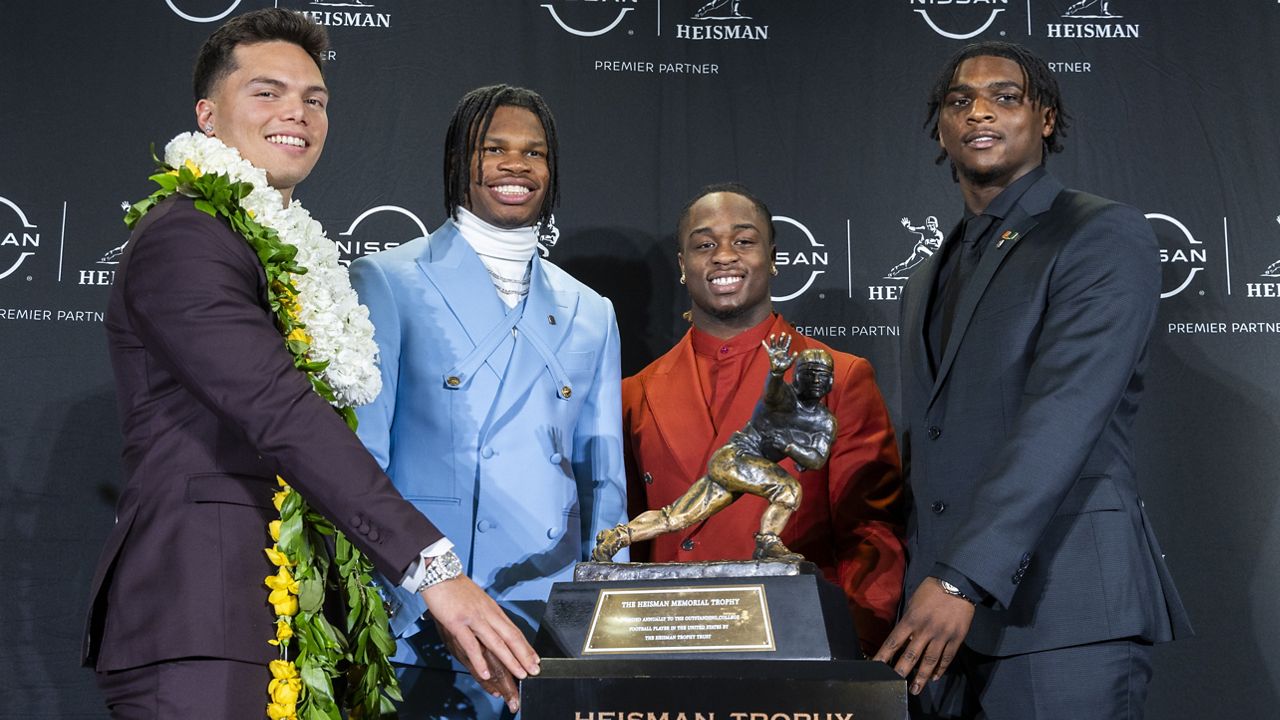 Heisman Trophy finalists, from left, Oregon's Dillon Gabriel, Colorado's Travis Hunter, Boise State's Ashton Jeanty and Miami's Cam Ward posed with the trophy on Saturday in New York.