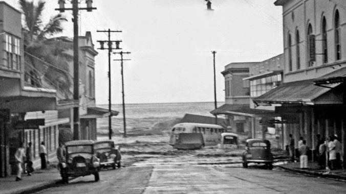 Not knowing what was to come, locals watch as the ocean swept up Waianuenue Avenue in downtown Hilo, HI on April 1, 1946. (PTM Kreschner Collection, courtesy of the Pacific Tsunami Museum)