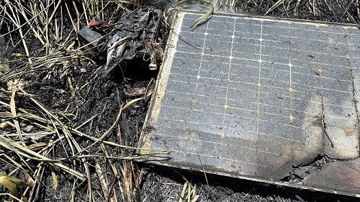 A scorched photovoltaic panel connected to a car battery is seen at the scene of the Kapaa Bypass road fire. (Photo courtesy of Kauai Fire Department)