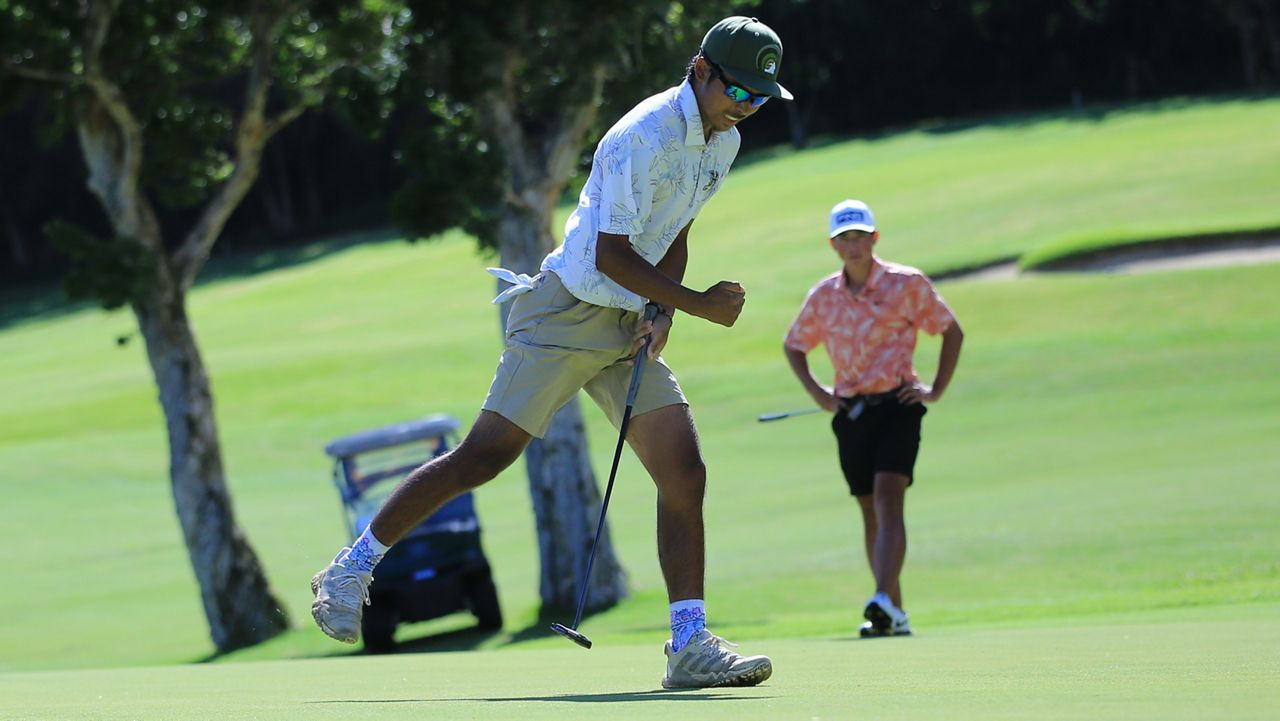 University of Hawaii golfer Anson Cabello pumped his fist after sinking an 11-foot putt on the No. 18 hole to force a playoff with Kahuku native Kihei Akina, background, in the Manoa Cup open division semifinals at Oahu Country Club on Friday.