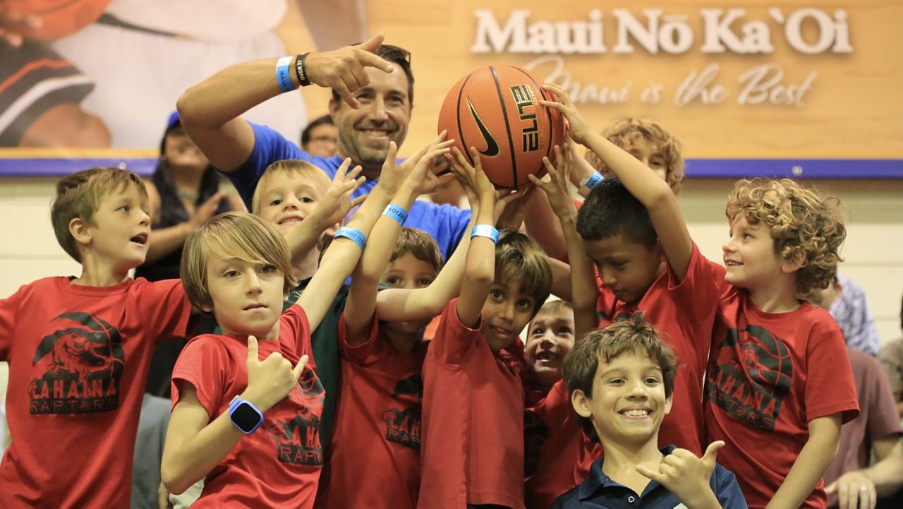 The Lahaina Raptors basketball team, including coach Daniel Sykes, top left, was honored with a game ball during the Michigan State-Colorado game on Day 1 of the Maui Invitational on Monday.