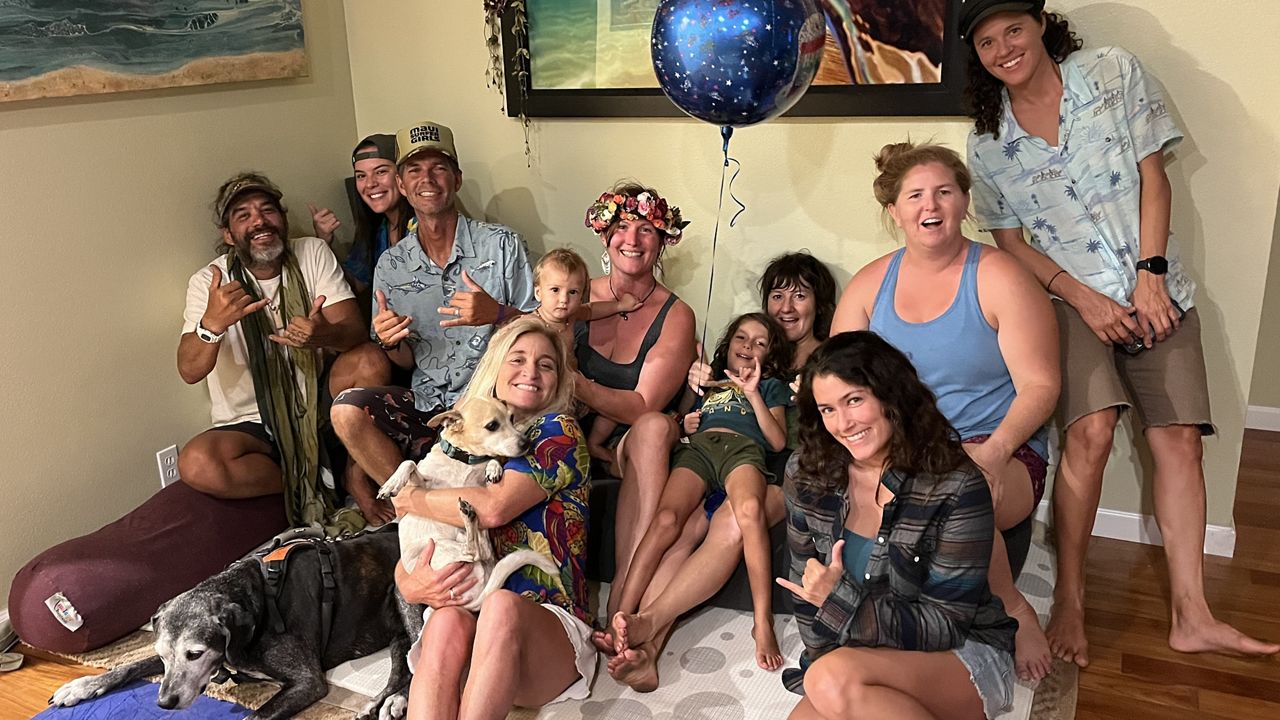 Dustin Tester (holding the dog) gathers with her staff after the Lahaina wildfire. Seven of the people in this photo lost their homes in the fire. (Photo courtesy of Dustin Tester)