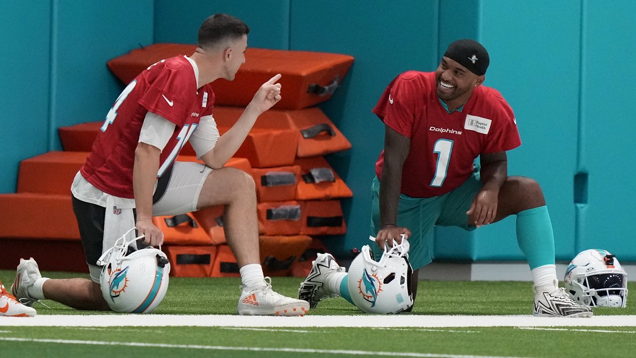 Miami Dolphins backup quarterback Mike White, left, talked with returning starter Tua Tagovailoa during training camp Wednesday in Miami Gardens, Fla.