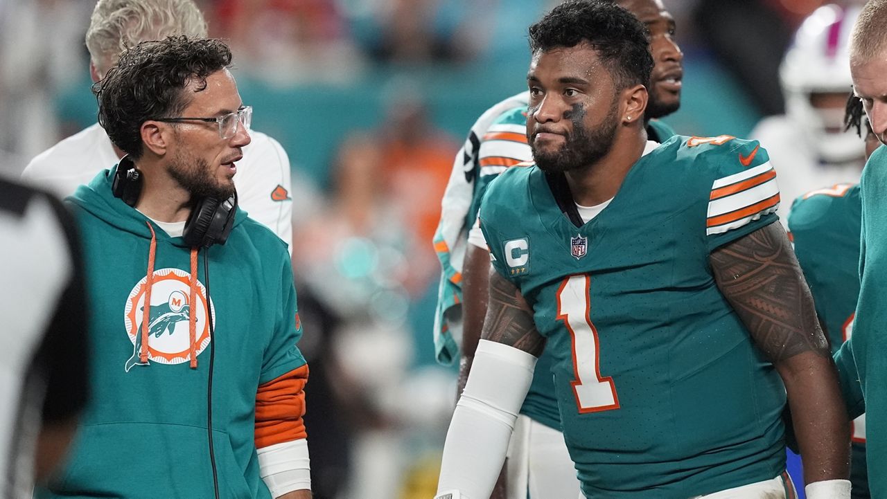 Saint Louis School graduate Tua Tagovailoa, right, walked off the field after suffering a concussion in the second half against the Buffalo Bills on Thursday. Coach Mike McDaniel was at left.