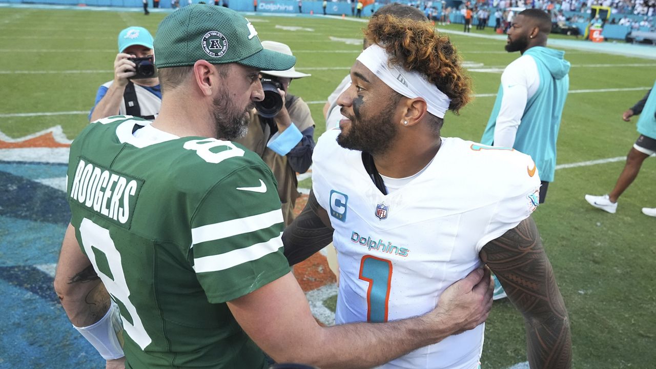 Miami quarterback Tua Tagovailoa and New York Jets quarterback Aaron Rodgers spoke at the end of the Dolphins' win in overtime at Hard Rock Stadium in Miami Gardens, Fla., on Sunday.