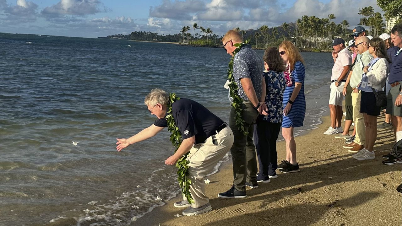 Eric Murray, father of the late PGA Tour player Grayson Murray, tossed a white orchid into the ocean during a celebration of life for his son at Waialae Country Club on Tuesday.