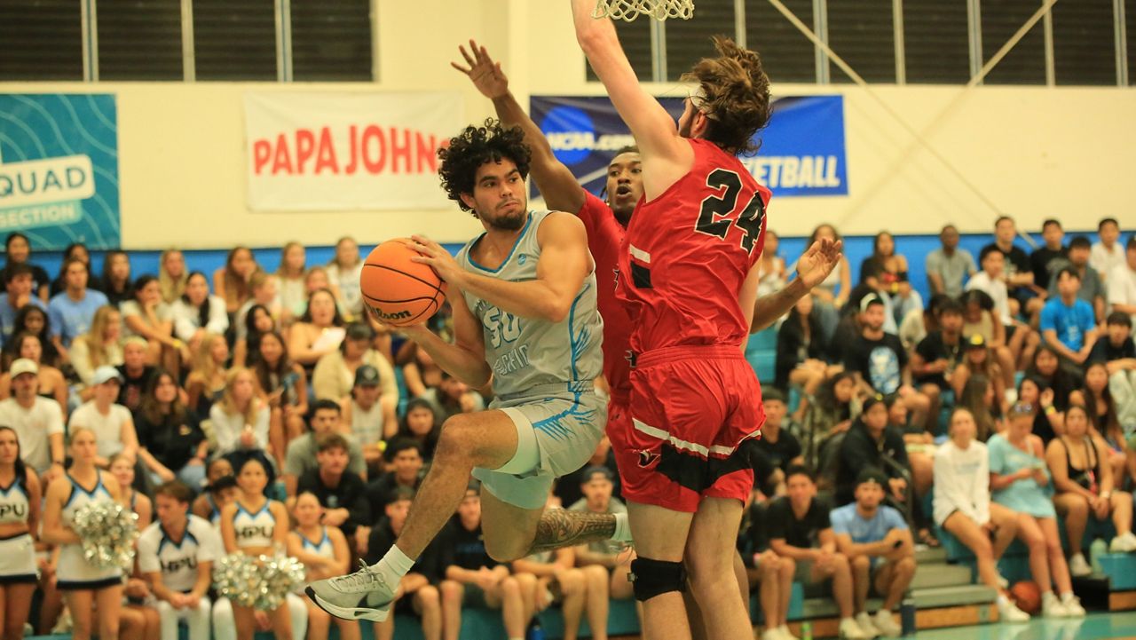 Hawaii Pacific airborne guard Kordel Ng looked to pass from underneath the basket as Hawaii Hilo's Julian Roberts (24) and Jarin Edwards converged at the Shark Tank on Thursday night.