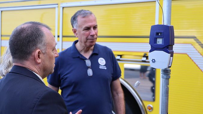 Gov. Josh Green and Dr. Dimitri Kusnezov, Under Secretary for Science and Technology, look at a Beta wildfire sensor. (Photo courtesy of the Office of Governor Josh Green)