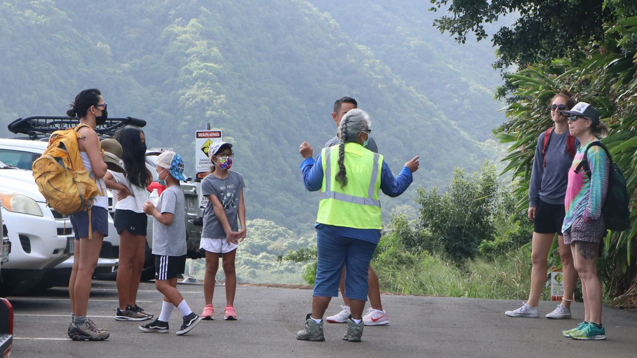 A trail steward talks with hikers and visitors at Pololu Valley on Hawaii Island. (Photo courtesy DLNR)