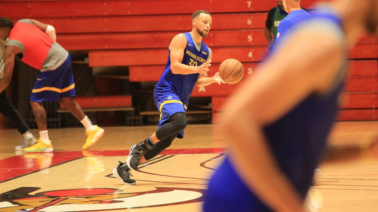 Golden State Warriors guard Stephen Curry took a handoff during a shooting drill after Day 1 of the team's training camp at BYU-Hawaii's Cannon Activities Center on Tuesday.