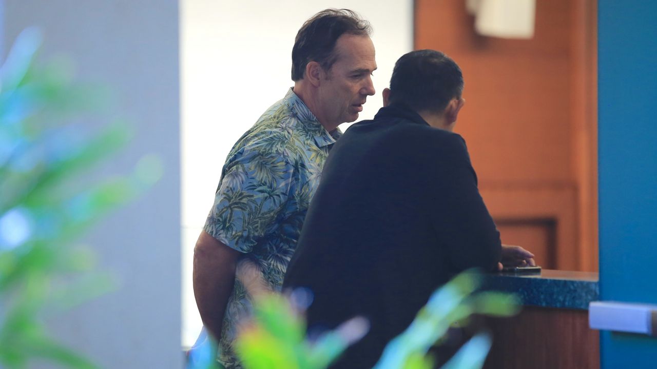 Hawaii Athletic Director Craig Angelos, center left, spoke to a UH Athletics staff member before an afternoon meeting at the Manoa Lower Campus in which Angelos discussed his termination by UH President David Lassner. 