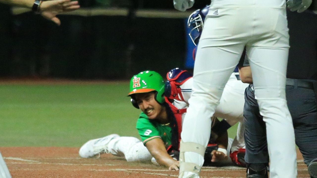 Hawaii first baseman Ben Zeigler-Namoa tried to get around Ole Miss catcher Campbell Smithwick in the fourth inning of 2024 opening night at Les Murakami Stadium. Zeigler-Namoa was ruled safe upon review, but the Rainbow Warriors fell in extra innings, 5-4.