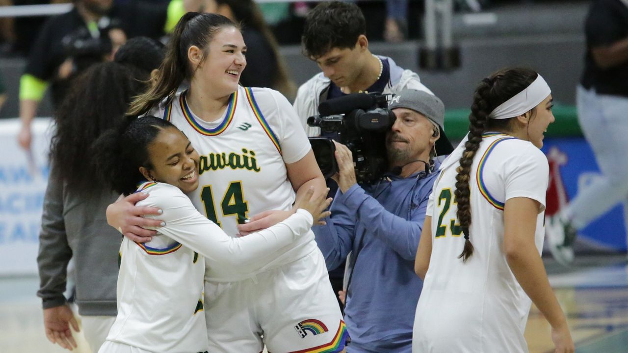 Hawaii guard Hallie Birdsong, left, was hugged by center Brooklyn Rewers after Birdsong hit the first shot of her Rainbow Wahine career late in Saturday night's rout of CSUN.