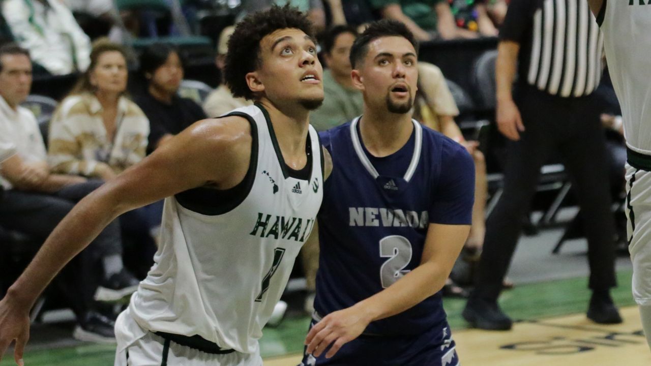 Hawaii men's basketball forward Justin McKoy and Nevada's Jarod Lucas looked at the basket when the Rainbow Warriors and Wolf Pack played at the Stan Sheriff Center on Dec. 17. UH and Nevada are former conference opponents from their WAC era and the possibility of sharing a league again is being explored.