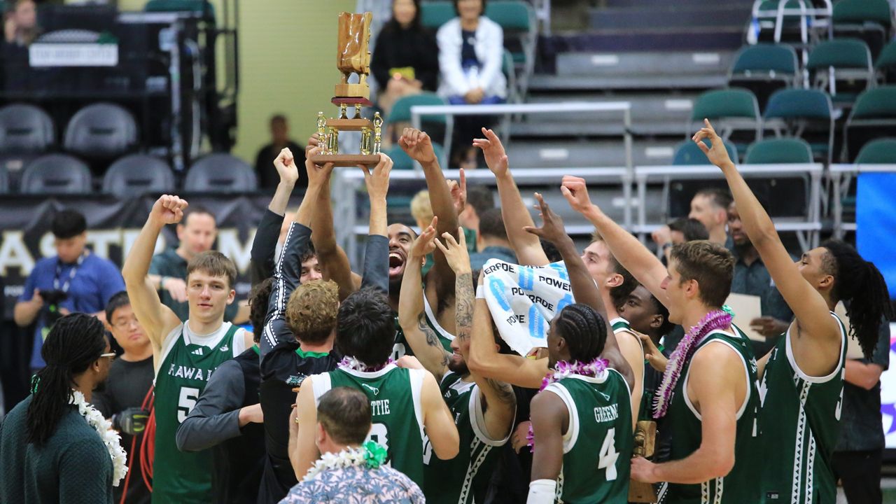 Hawaii players celebrated with the Outrigger Rainbow Classic trophy after beating Pacific at the Stan Sheriff Center on Monday night.