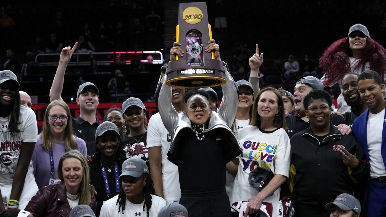 Former University of Hawaii women's basketball associate head coach Mary Wooley, bottom left, celebrated with South Carolina as a member of Dawn Staley's victorious coaching staff after the NCAA championship game against Iowa in Cleveland on Sunday.