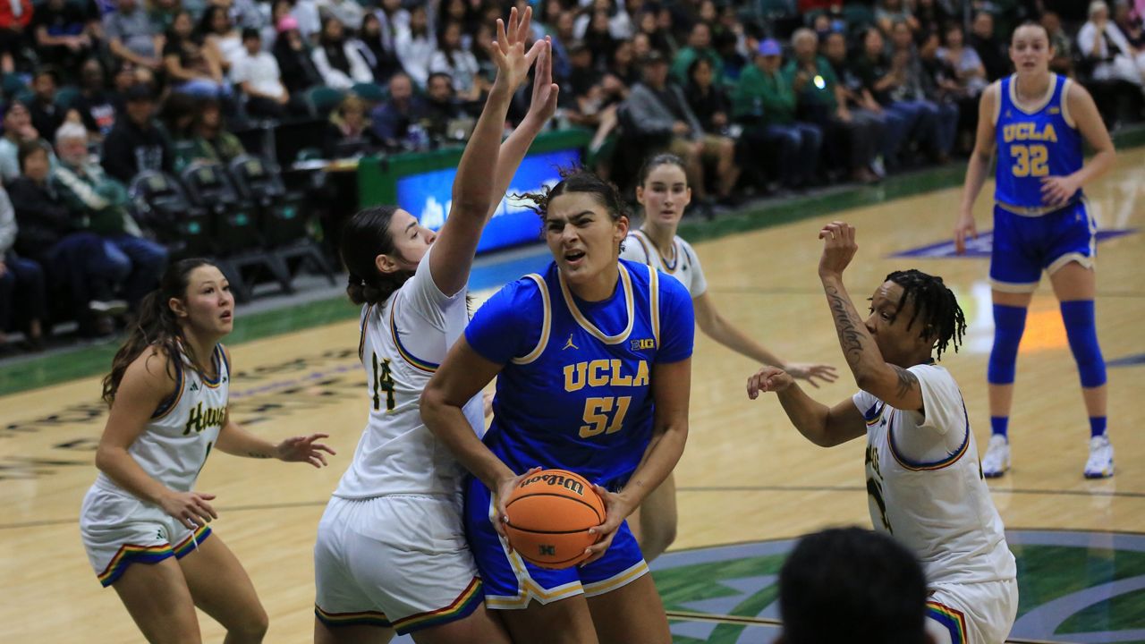 UCLA post Lauren Betts went to work against Hawaii's Brooklyn Rewers (14) and Daejah Phillips, right, in the paint on Sunday afternoon.