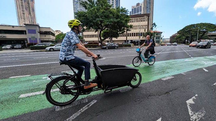 E-bike rider on King Street's protected bike lane. (Photo courtesy of Department of Transportation)