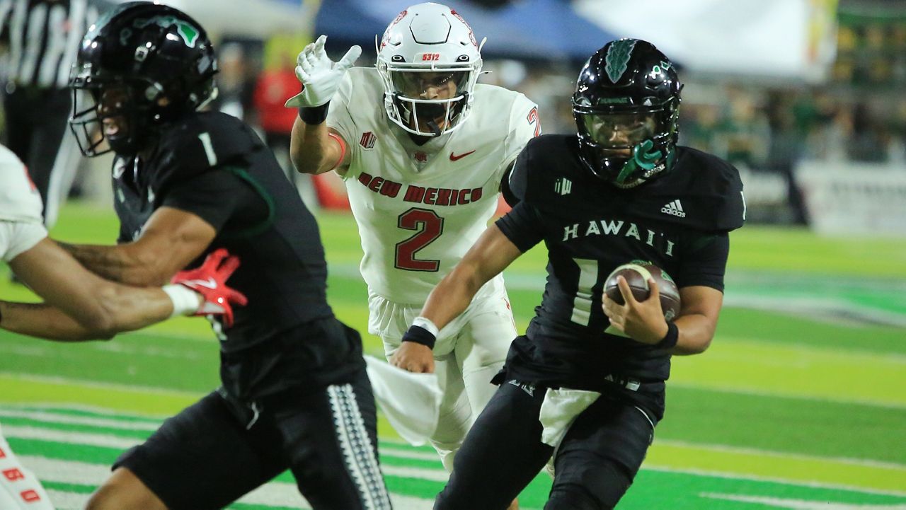 Hawaii quarterback Micah Alejado, right, followed the block of Jonah Panoke and evaded New Mexico safety Noa Pola-Gates for keeper yardage in the fourth quarter to clinch the win on Saturday night.