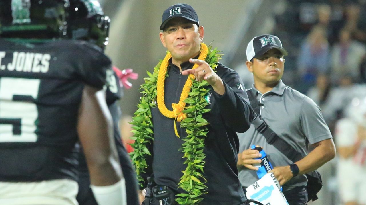 Hawaii football coach Timmy Chang, middle, pointed out instructions to his players in the second half of Saturday's home finale against New Mexico.