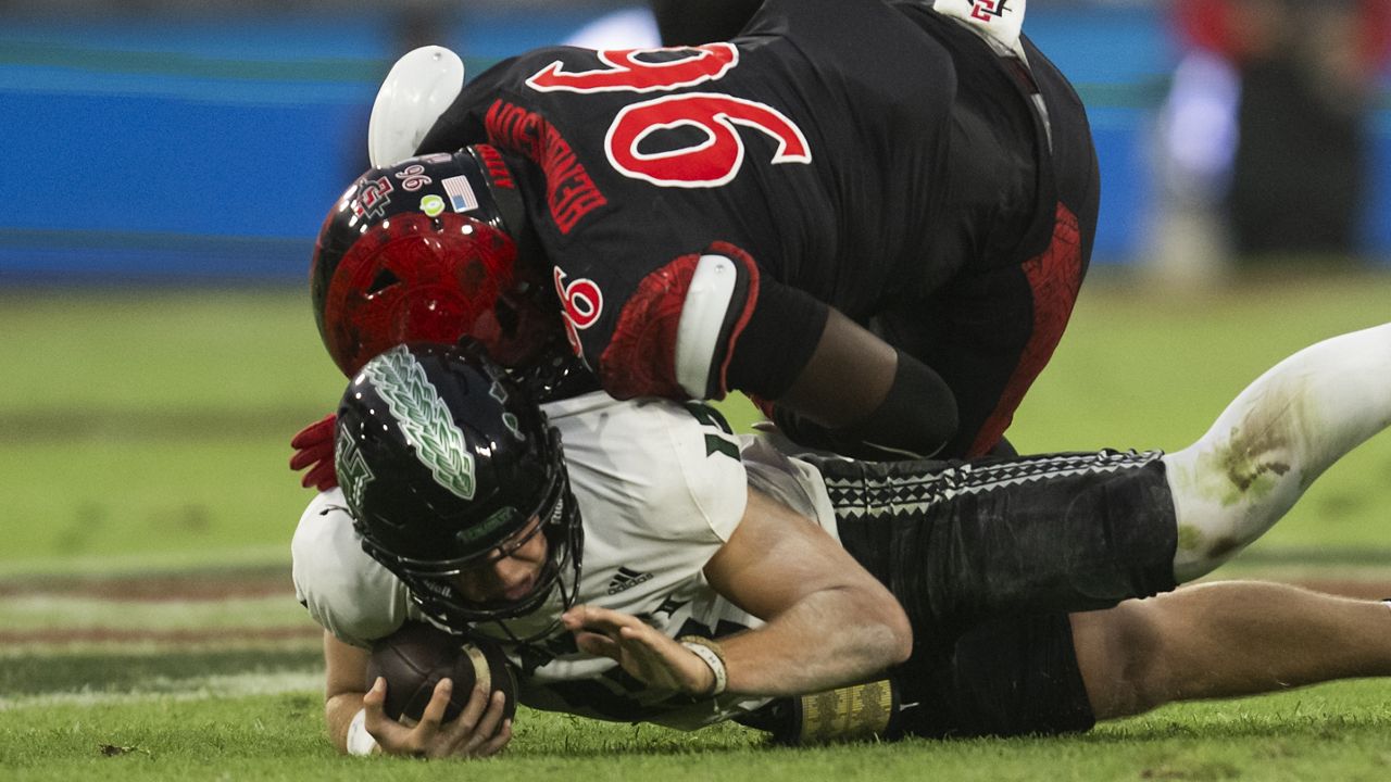 San Diego State defensive end Ryan Henderson fell onto Hawaii quarterback Brayden Schager in the first half at Snapdragon Stadium in San Diego. Henderson was disqualified from the game for targeting on the play.