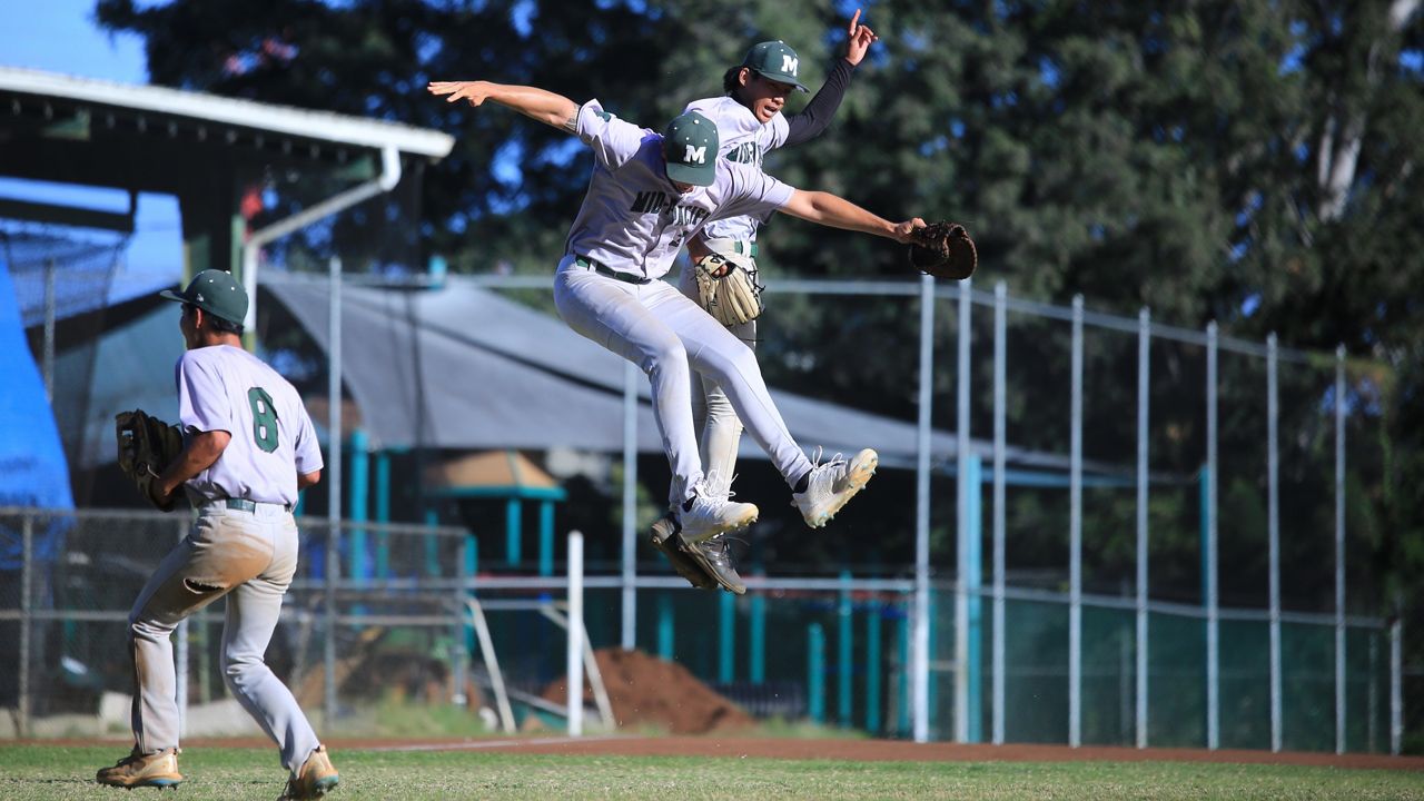 Mid-Pacific Institute pitcher Payton Dixon, right, met first baseman Chandler Murray in midair after the Owls beat Kamehameha 2-1 at Damon Field on Wednesday afternoon. (Spectrum News/Brian McInnis)