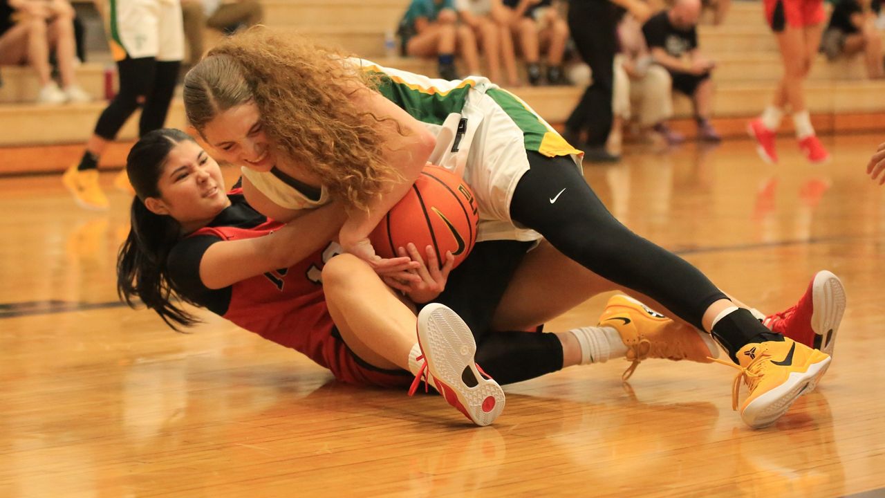 Iolani guard Mia Frye, bottom, grappled with Pinewood's Caitlyn Kramer for a loose ball in the first half.