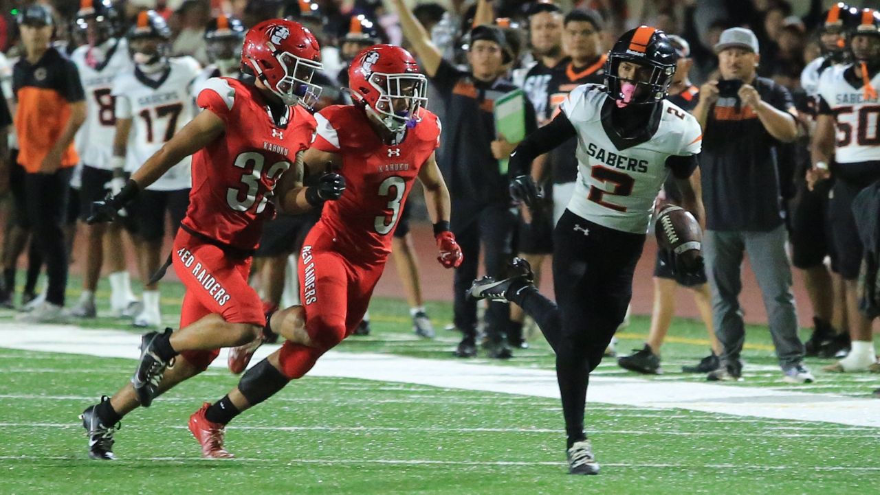 Campbell receiver Zayden Alviar-Costa, right, caught a pass from Jaron-Keawe Sagapolutele and tried to elude Kahuku defensive backs Lono Solomon (32) and Manoa Kahalepuna (3).