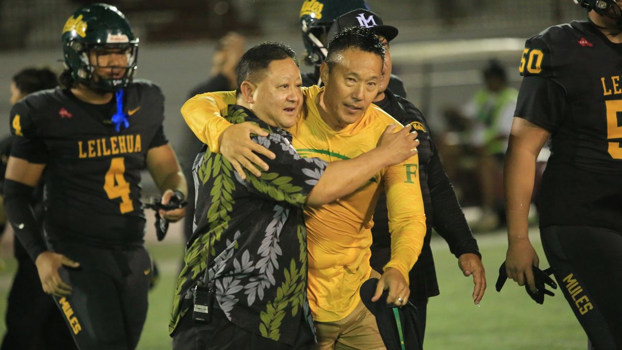 Leilehua football coach Mark Kurisu, center right, hugged Mules athletic director and former coach Nolan Tokuda after a win over Kailua in the OIA Division I championship game on Saturday night at Farrington.