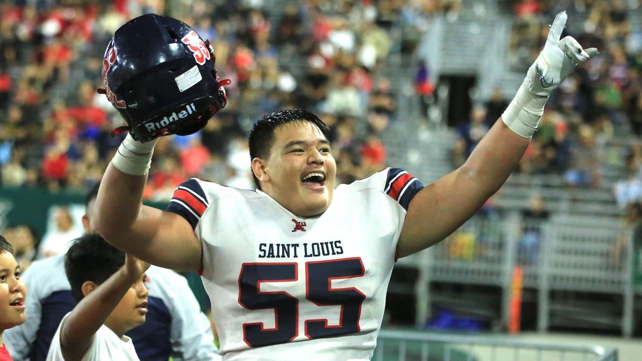 Saint Louis defensive lineman Stone Ah Quin pointed to Crusaders fans in the crowd after his interception of Kahuku quarterback Matai Fuiava in the second half on Friday night.