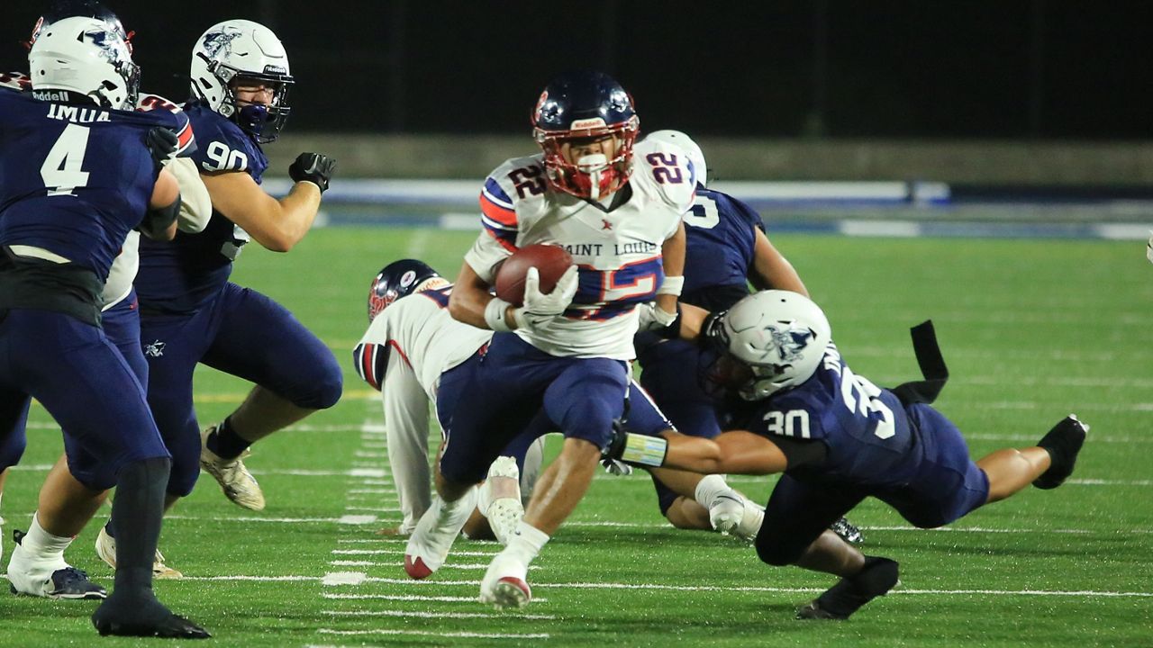 Saint Louis running back Titan Lacaden burst through a hole up the middle against Kamehameha at Kunuiakea Stadium on Friday night.