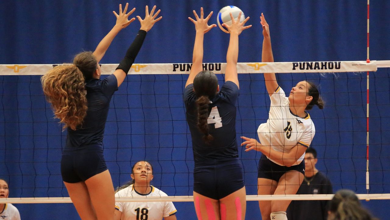 Punahou's Sage Clarke hit into the block of Kamehameha's Kalamaku Crabbe (4) and Bella Amey at Hemmeter Fieldhouse on Friday night.